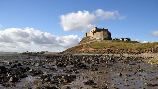 View of castle and boat sheds from the beach, Lindisfarne Castle, Northumberland